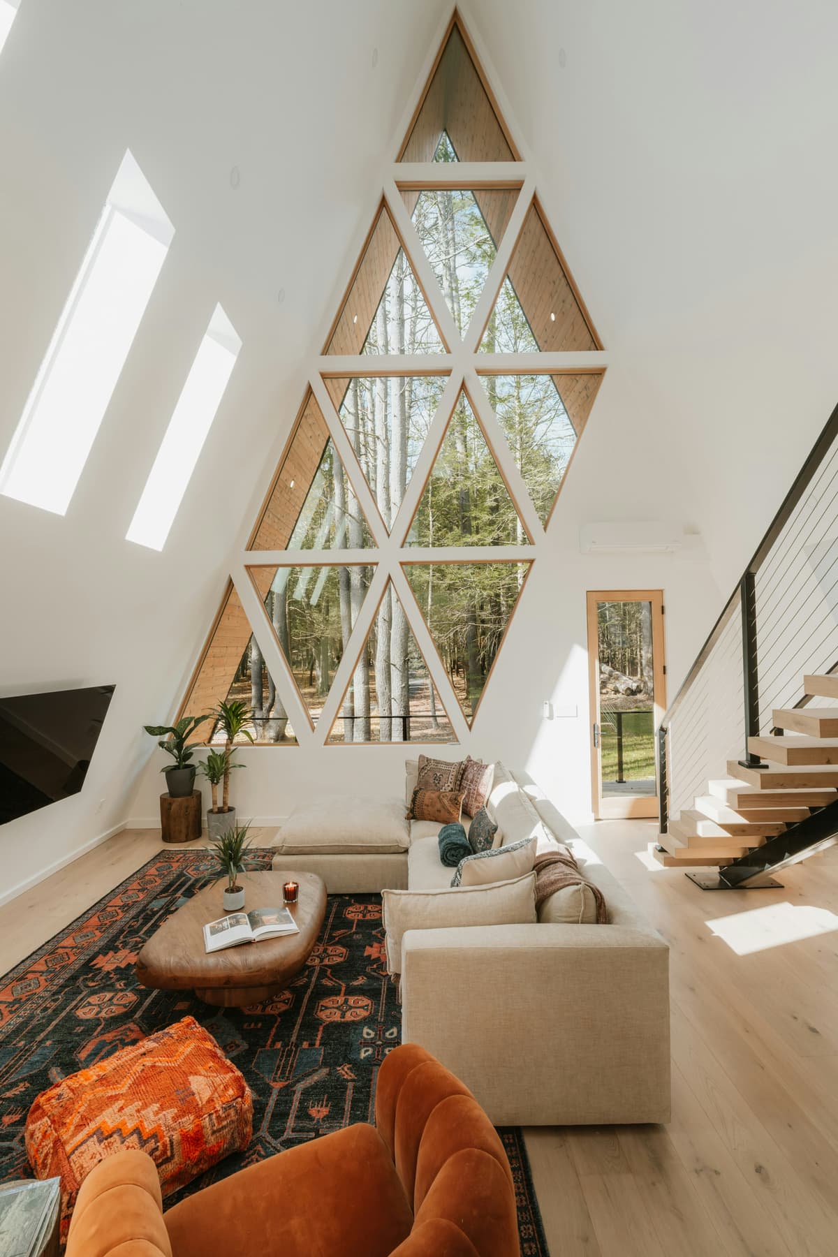 Bright A-frame living room with white painted walls and timber window frames in a Duffield home